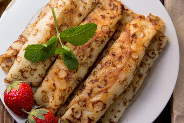 fried pancakes and strawberries closeup on a wooden table. Dessert. Healthy breakfast. Proper nutrition