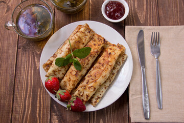 fried pancakes and strawberries closeup on a wooden table. Dessert. Healthy breakfast. Proper nutrition