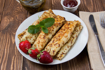 fried pancakes and strawberries closeup on a wooden table. Dessert. Healthy breakfast. Proper nutrition