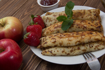 fried pancakes and strawberries closeup on a wooden table. Dessert. Healthy breakfast. Proper nutrition