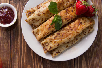 fried pancakes and strawberries closeup on a wooden table. Dessert. Healthy breakfast. Proper nutrition