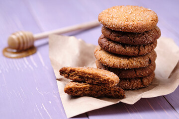 Tower of oatmeal cookies with honey. Dessert on brown paper, on the table close-up.