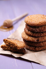Tower of oatmeal cookies with honey. Dessert on brown paper, on the table close-up.