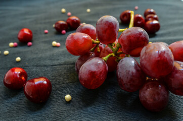 grapes and cherries on a black background