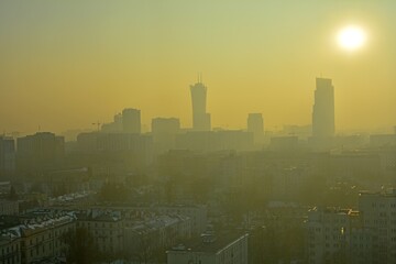 View of a modern cityscape covered in a dense smog and pollution, during sunset