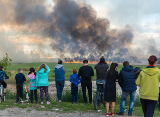A crowd of people watching the fields burn