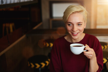 Caucasian young female enjoying cappuccino drink in coffee shop