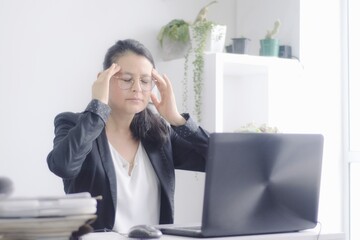 Joven mujer empresaria sufre de estrés frente a su computadora por exceso de trabajo. Ejecutiva...