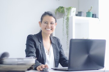 Joven mujer de negocios sonríe mientras trabaja en la computadora portátil. Mujer trabajando
