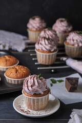 The process of making holiday cupcakes with pink cream. The dessert is decorated with mint leaves and chocolate chips.