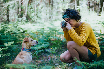 mujer haciendo fotos a un perro en la montaña