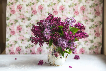 Bouquet of violet lilac in a vase. Still life with blooming branches of lilac in vases.