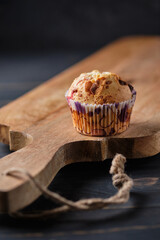 Berry chocolate muffin with raspberries and strawberries on a large wooden board.