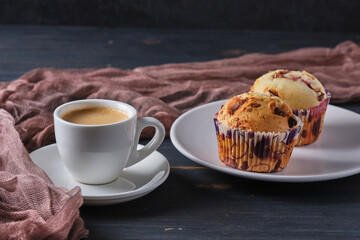 Espresso and muffins with berries and chocolate on a plate. Coffee and dessert for breakfast.