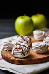 Homemade handmade apple marshmallows on a wooden board. The dessert is poured with chocolate.