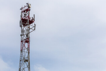 3G, 4G, 5G, wireless and cell phone telecommunication tower close-up on cloudy daylight sky background with copy space