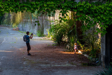 Fototapeta na wymiar Little girl with her father among greenery 