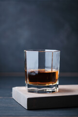 Glass of whiskey on a wooden board in a bar. Bar counter with an alcoholic drink.