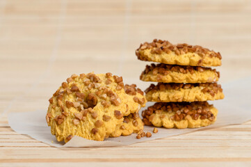 Round homemade cookie lies on parchment on a wooden surface.