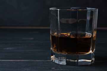 Glass of whiskey on a wooden table in a bar. Bar counter with an alcoholic drink.
