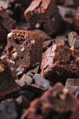 Chocolate is poured on brownie with nuts. Sweet and tasty dessert close-up on a wooden table. Soft focus.