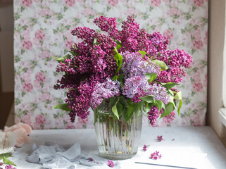 Bouquet of violet lilac in a vase. Still life with blooming branches of lilac in vases.