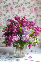 Bouquet of violet lilac in a vase. Still life with blooming branches of lilac in vases. Greeting card mock up. Space for text.