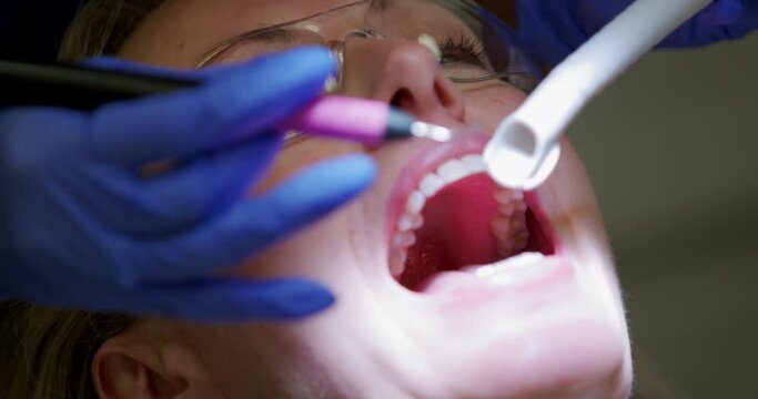 CU SELECTIVE FOCUS Dentist examining teeth of patient at dentist's office / Hove, Sussex, UK