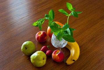 Mint in a glass and fruit - peaches, pears, grapefruit, bananas, strawberries. 