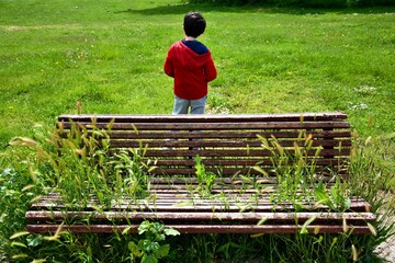 one boy and one bench full of plants in a park