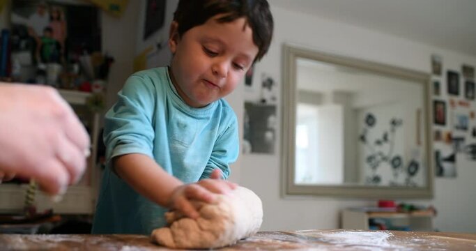  Mother and son kneading dough in kitchen