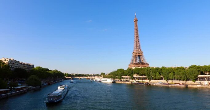 Eiffel Tower and barges on Seine River on sunny day