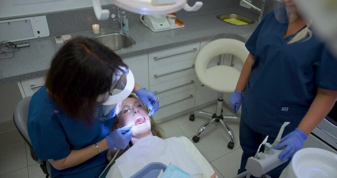 MS HA Dentist examining teeth of patient at dentist's office / Hove, Sussex, UK