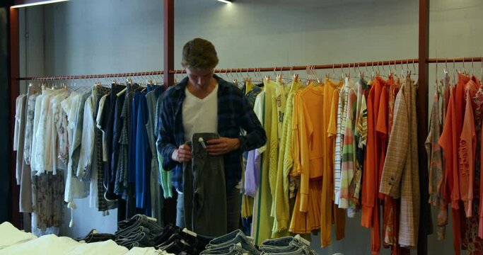WS TS Man putting clothing in boutique at King's Cross / London, UK