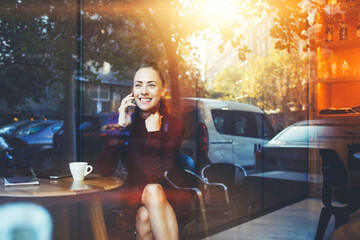 Attractive female watching video or reading business weblog in network on cell telephone