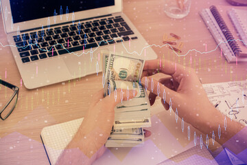 Multi exposure of financial graph drawing hologram and USA dollars bills and man hands. Analysis concept.