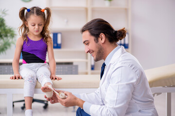 Fototapeta premium Small girl visiting young male doctor