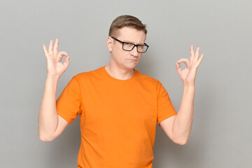 Portrait of serious confident man showing okay gestures with fingers