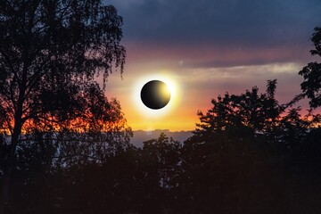 Colorful eclipse of the Sun in clouds sky , apocalypse sunset