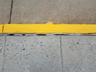 yellow paint and cement curb