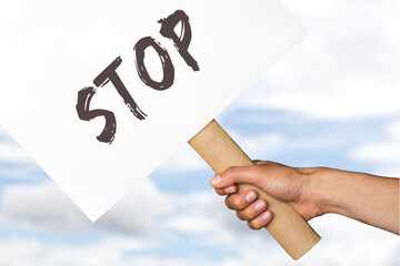activist with a stop poster. protest banner on cloudy sky background