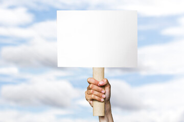 activist with an empty poster. protest banner on cloudy sky background