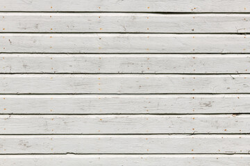 White wooden wall with rich texture, cracks, knots, and nails. Weathered timber planks background.