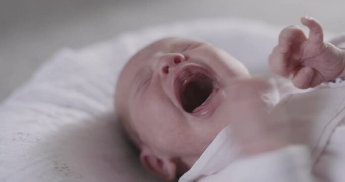 High angle close up of crying newborn baby girl.
