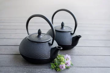 Foto op Aluminium Two Black Metal Tea Pots on a light brown wooden background © mBoo