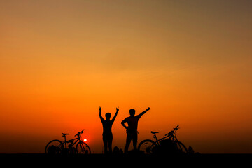 Fototapeta na wymiar Family cyclist and Bicycle silhouettes on the dark background of sunsets