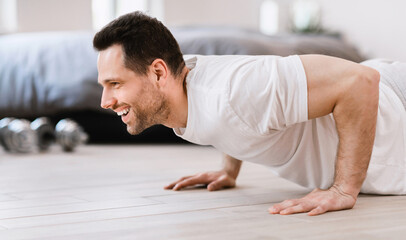 Happy Man Doing Plank Exercise Training Indoors On Weekend Morning
