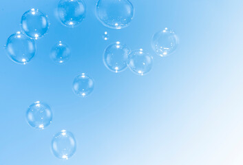 Beautiful blue soap bubbles float as background.
