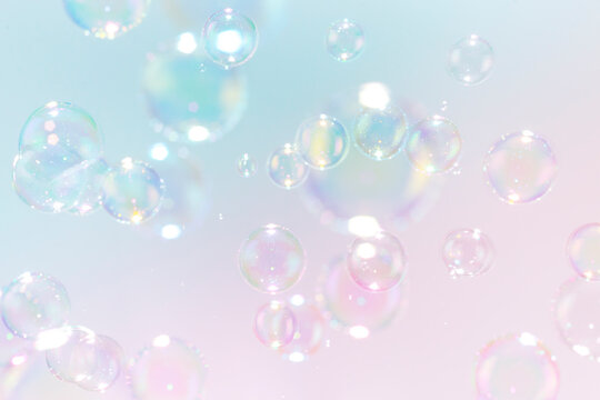 Beautiful rainbow soap bubbles float as background.
