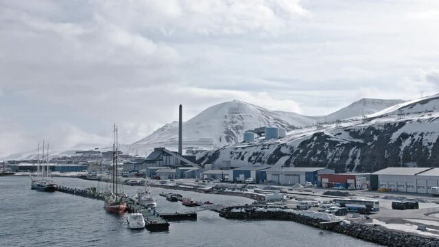 Longyearbyen town harbour docks and buildings,  waterfront with boats moored.